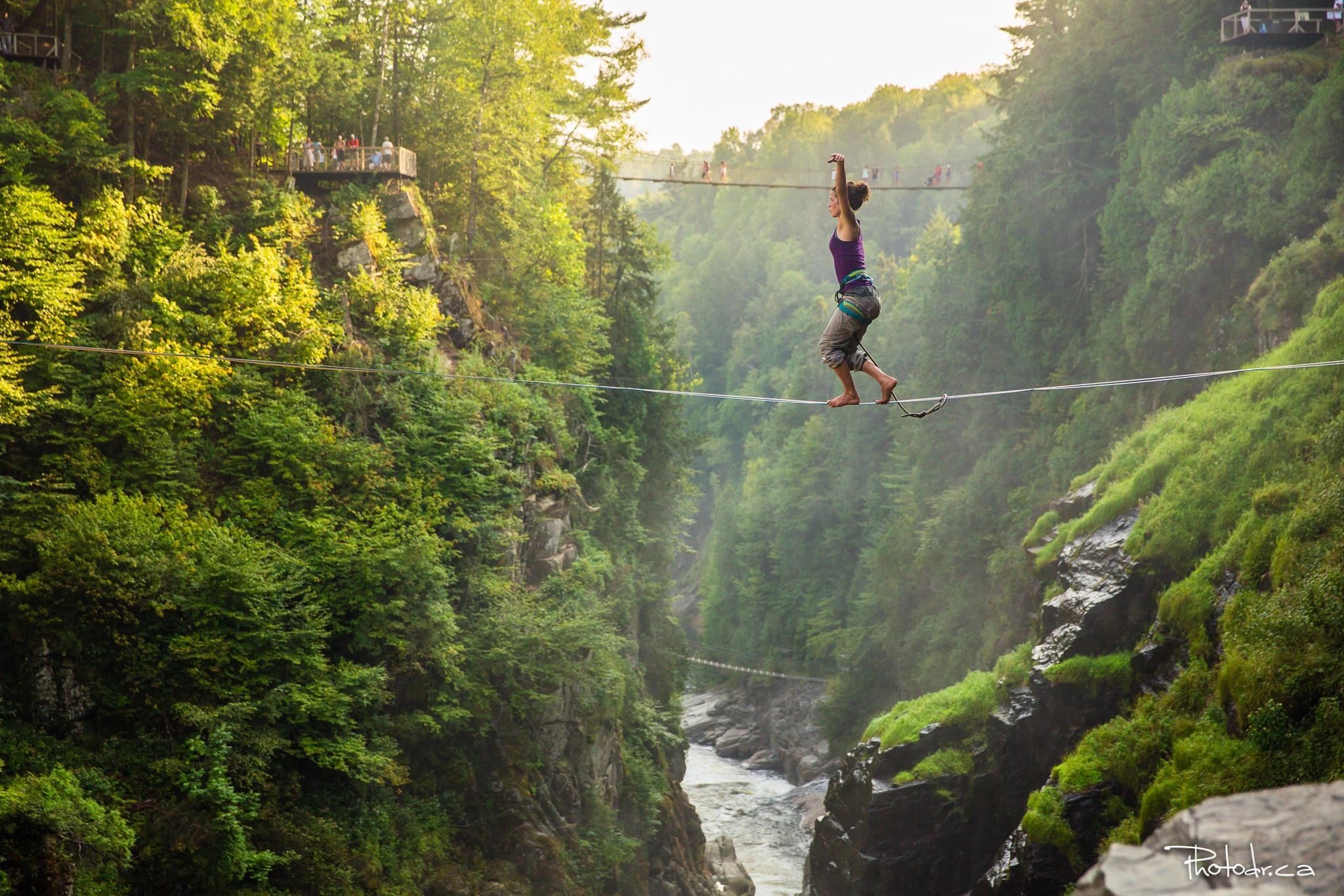 A participant crosses a gorge on a highline above the river