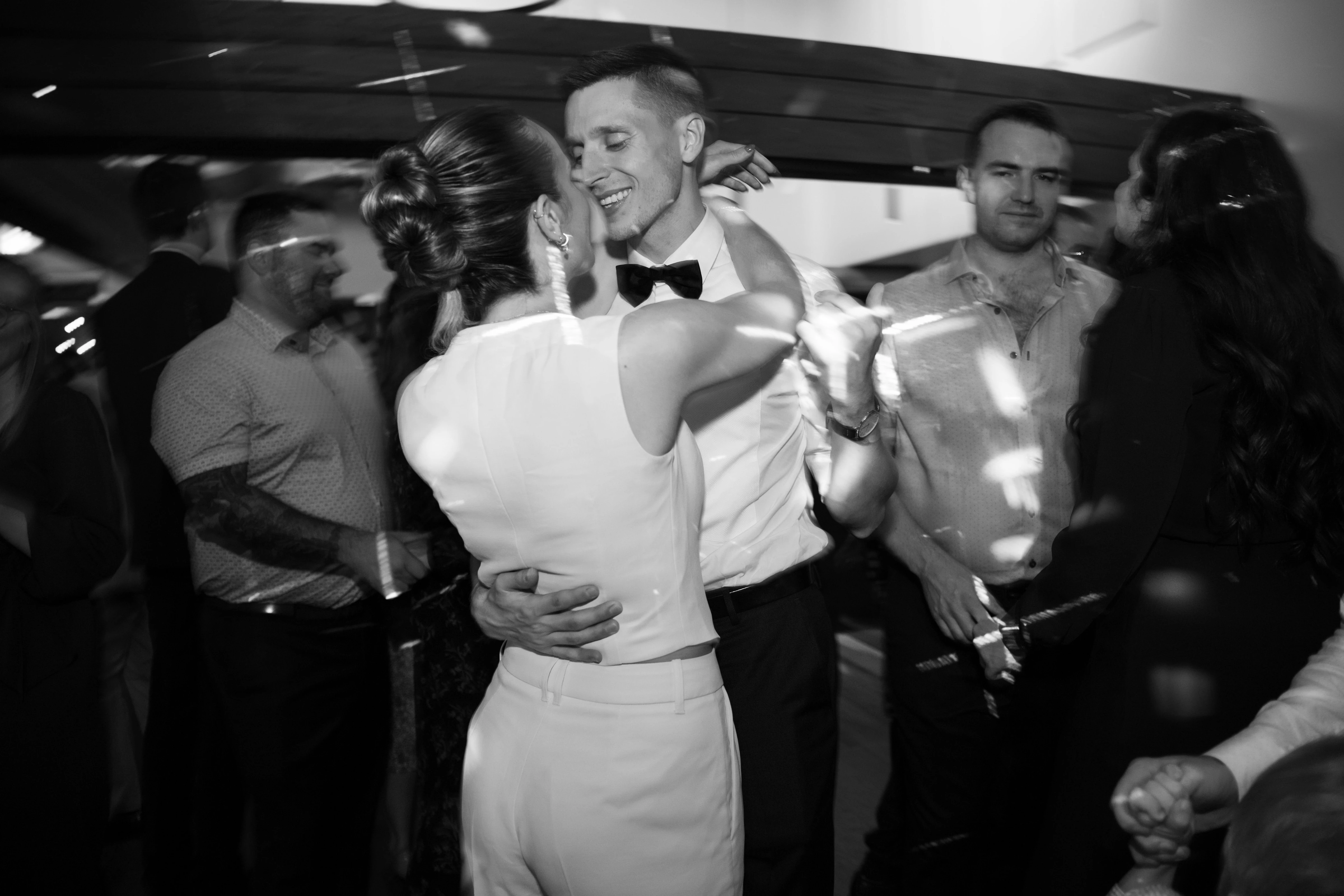 Two loved ones embrace on the dance floor in black and white