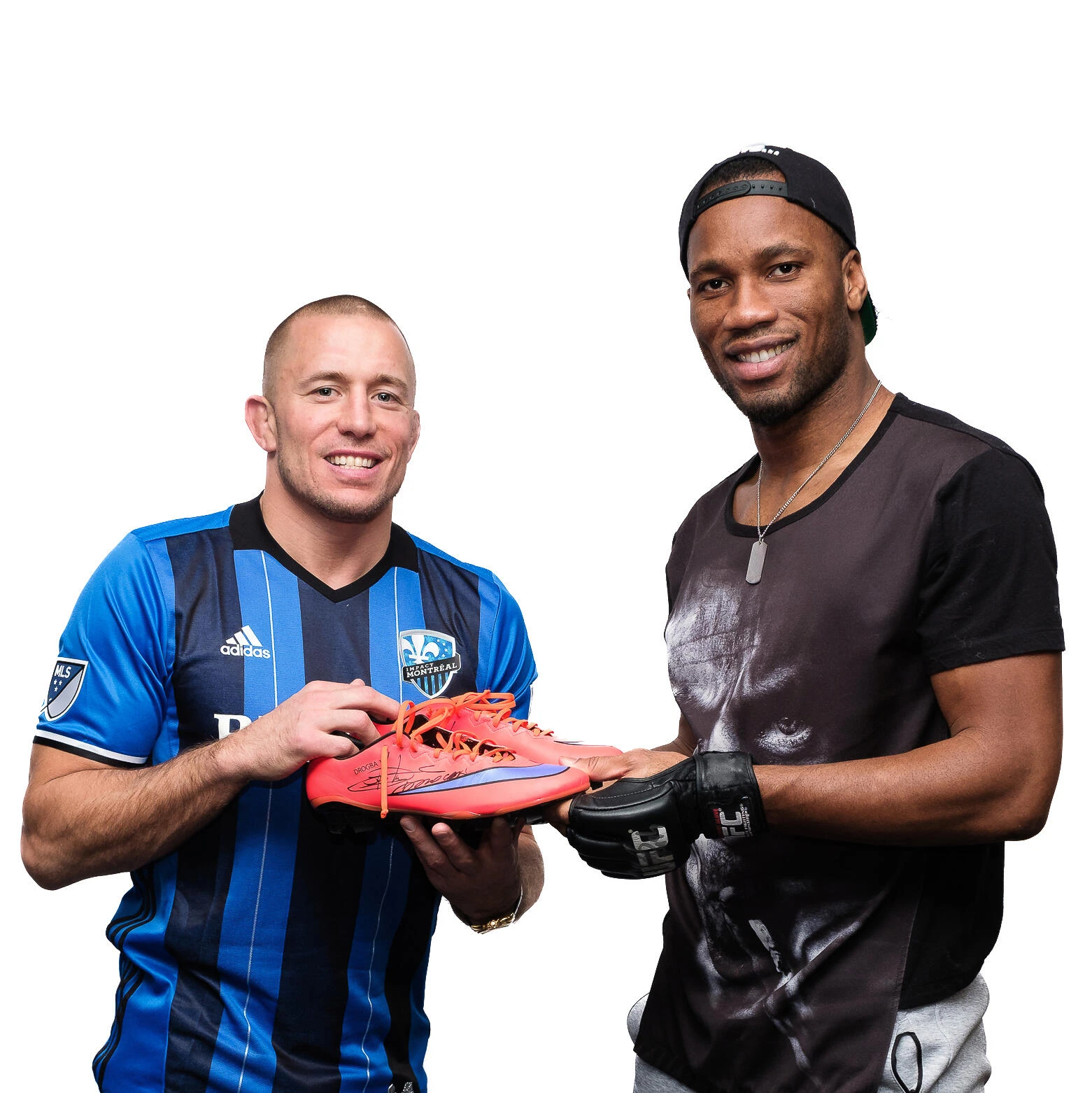 Two smiling athletes hold a red soccer shoe together against a white background