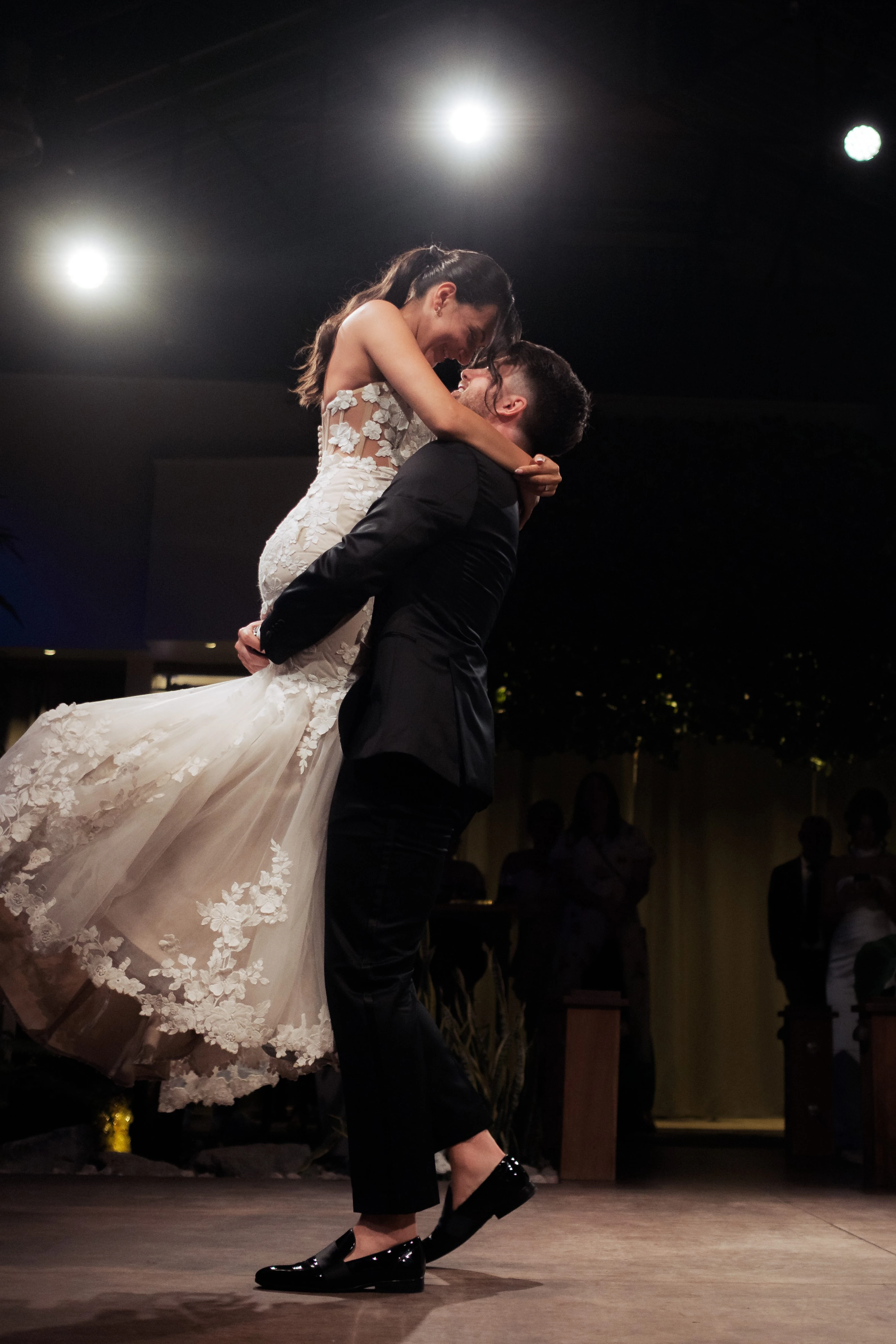 The newlyweds kiss in a barn doorway in golden light