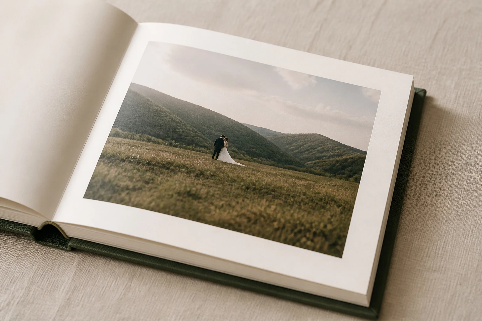 An open wedding album showing a couple in the mountains