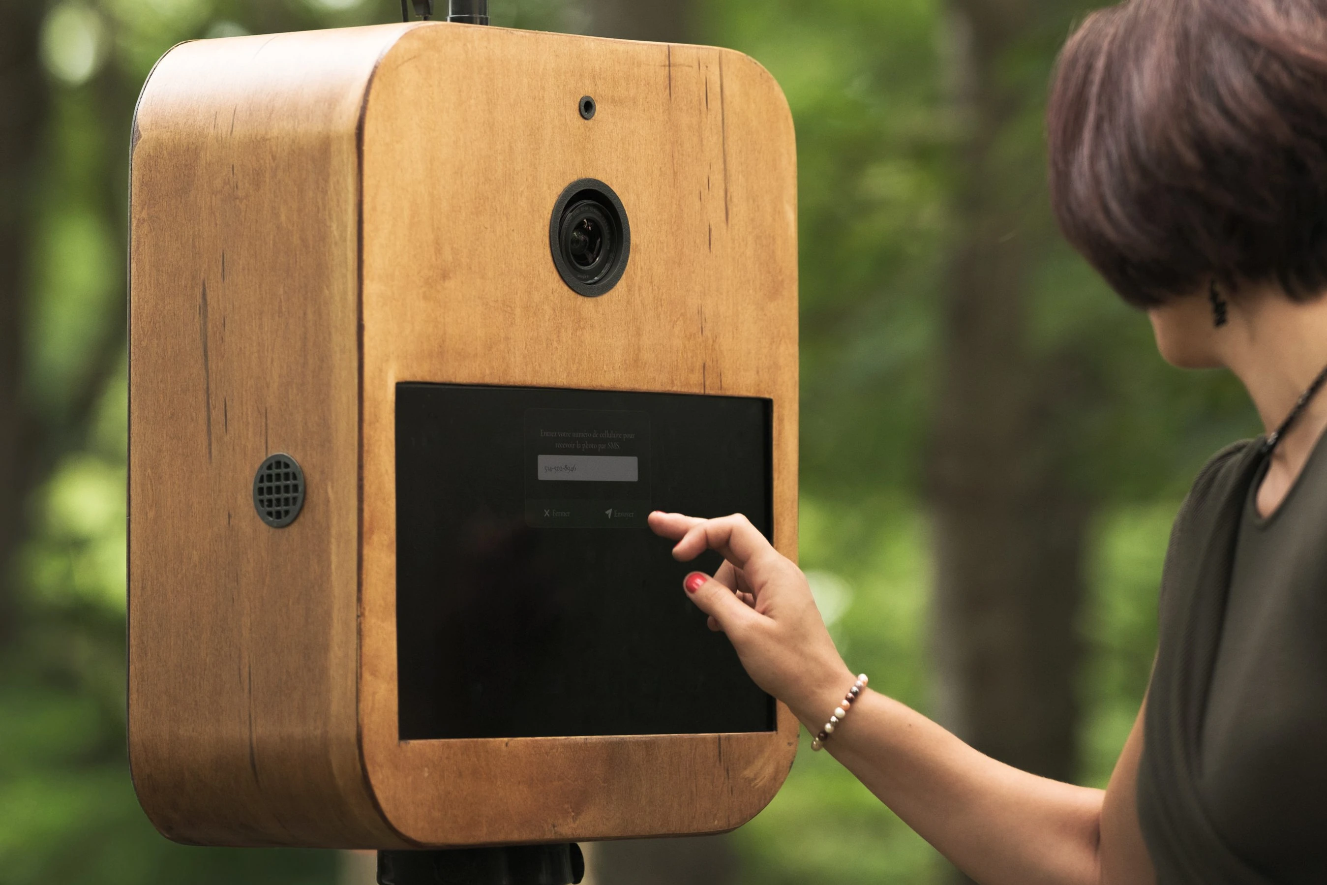 Le Photobooth du Nord en bois devant des arbres